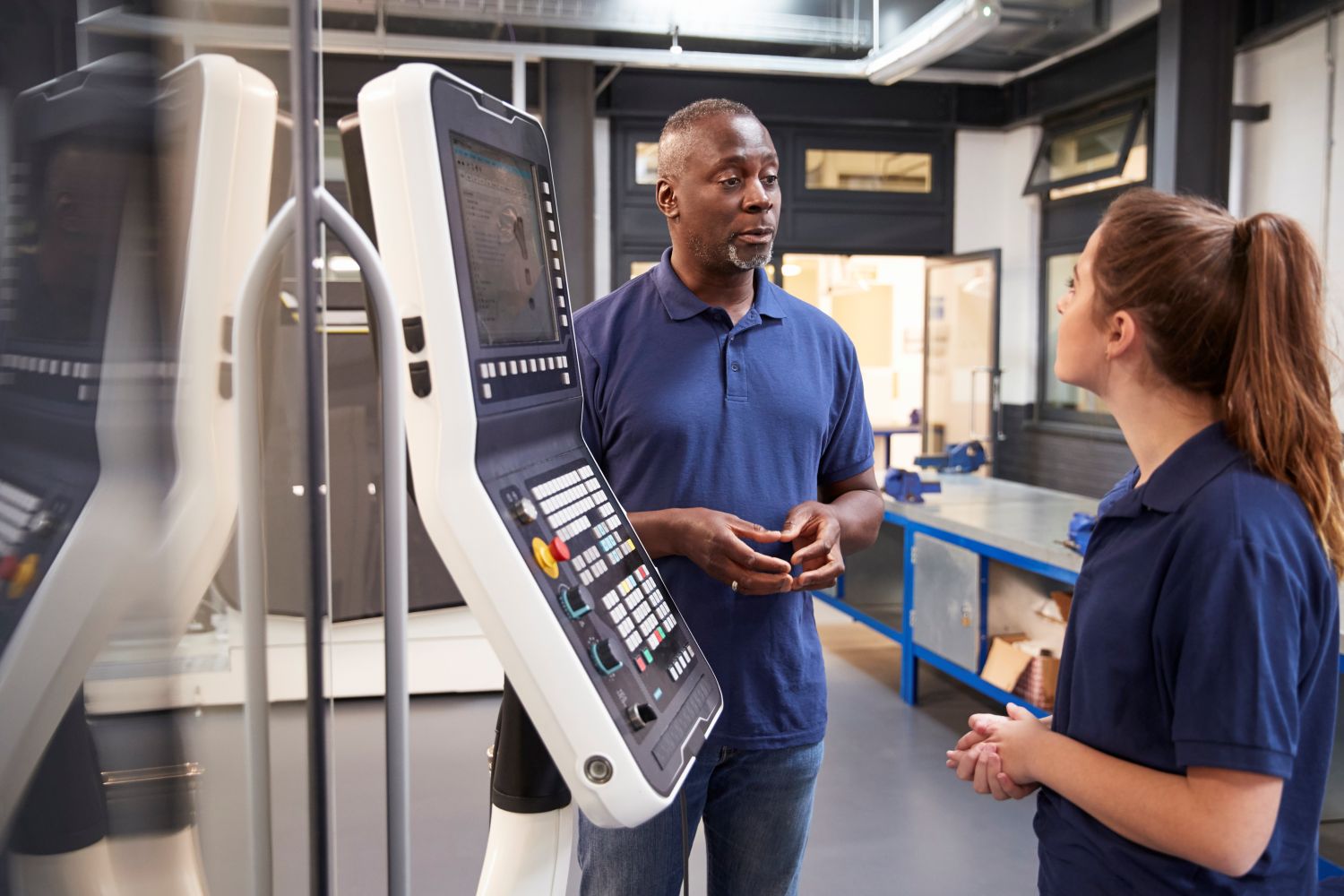 engineer showing woman how to use CNC